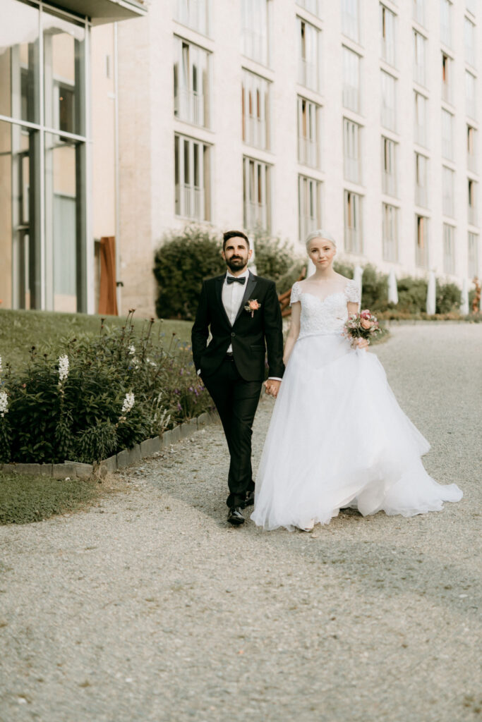 Couple walking outside the luxury hotel at their wedding in Switzerland