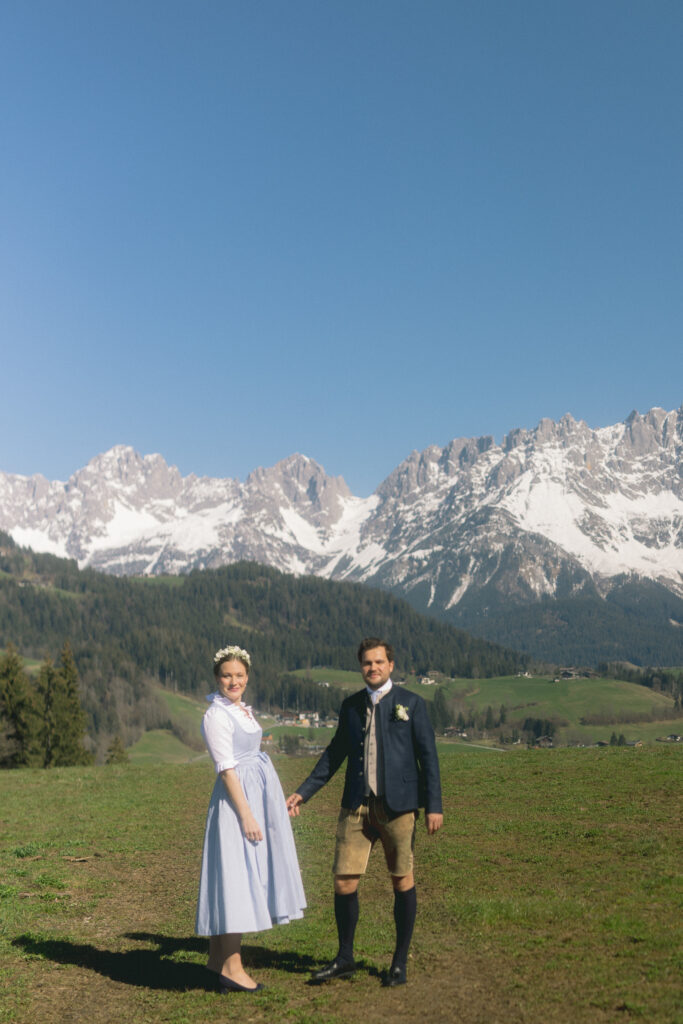 Brautpaar in Kitzbühel auf Wiese in Sonnenschein